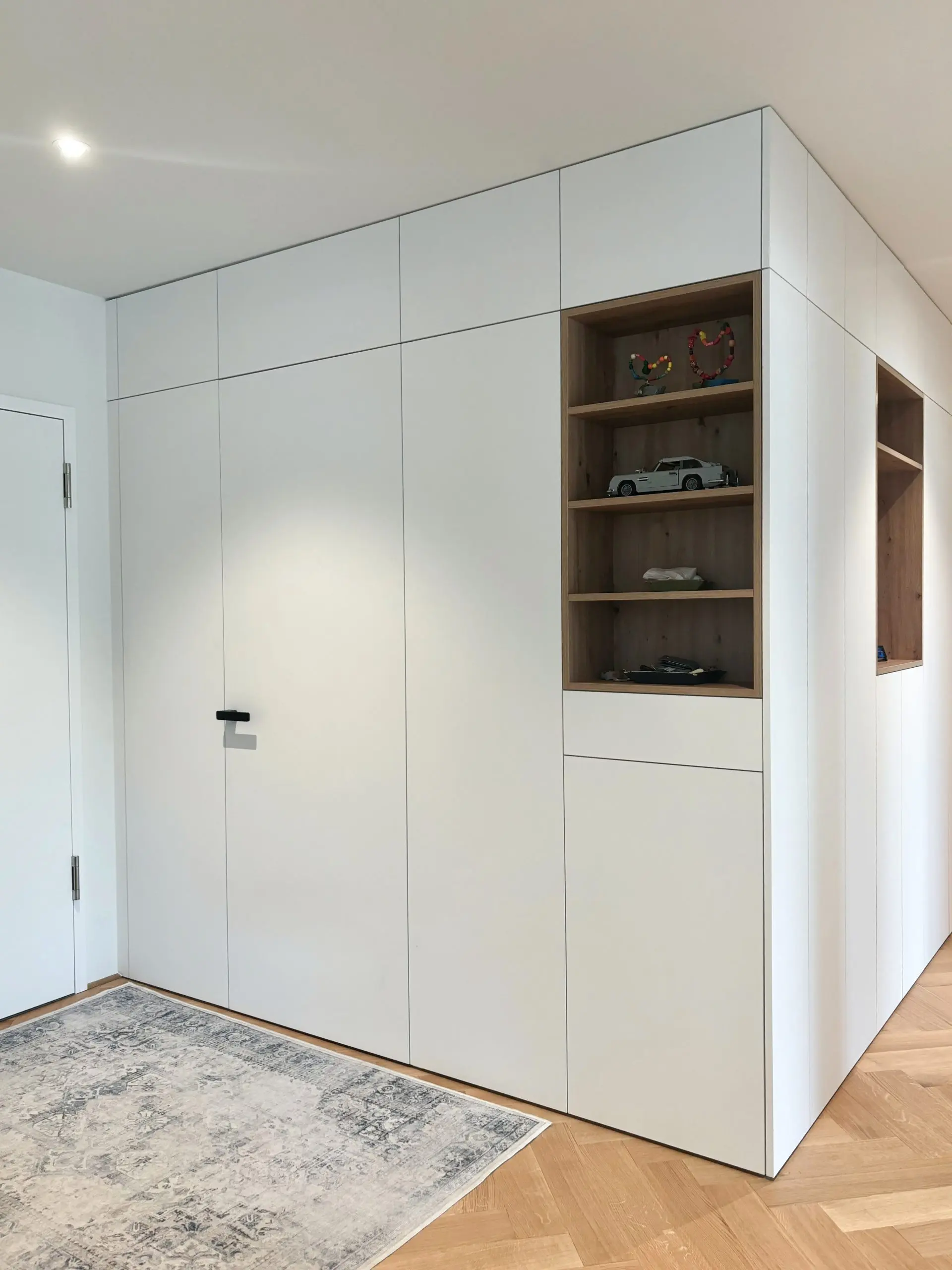 Weißer, raumhoher Einbauschrank mit offenem Fach aus Holz