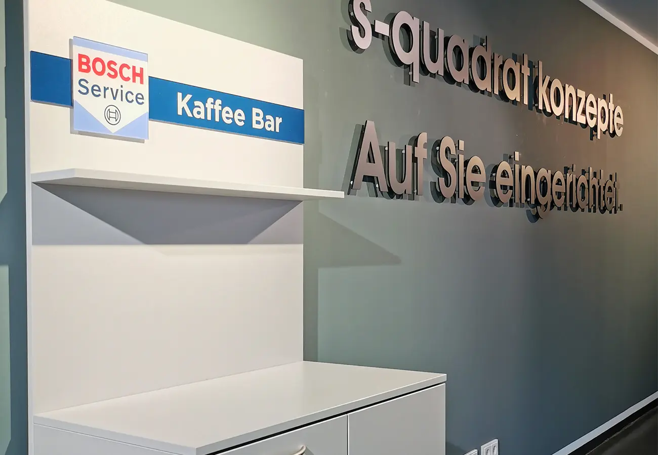 Kaffeebar-Element vor der Wand mit dem Schriftzug s-quadrat konzepte