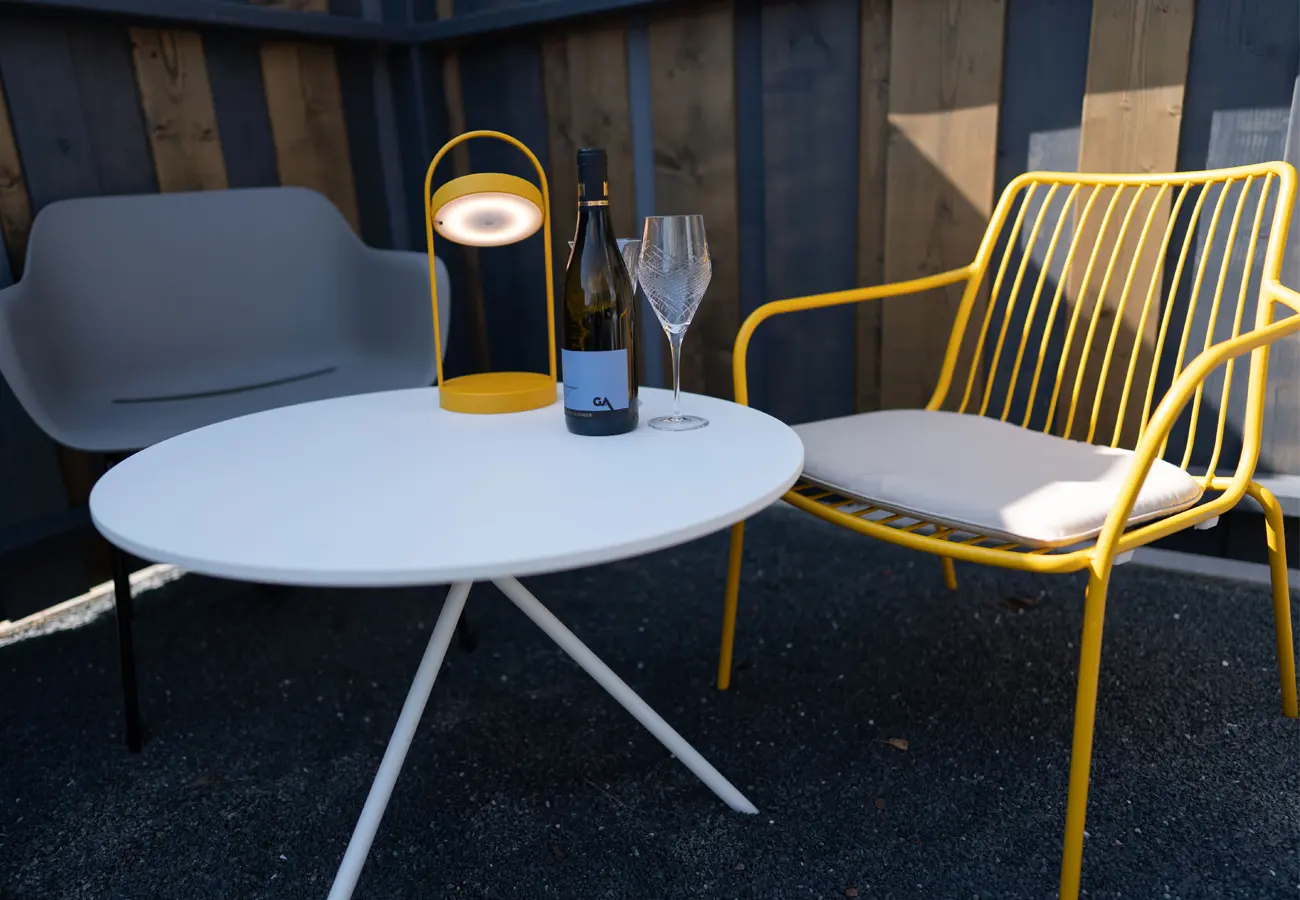 Beistelltisch mit Leuchte zwischen zwei Gartensesseln