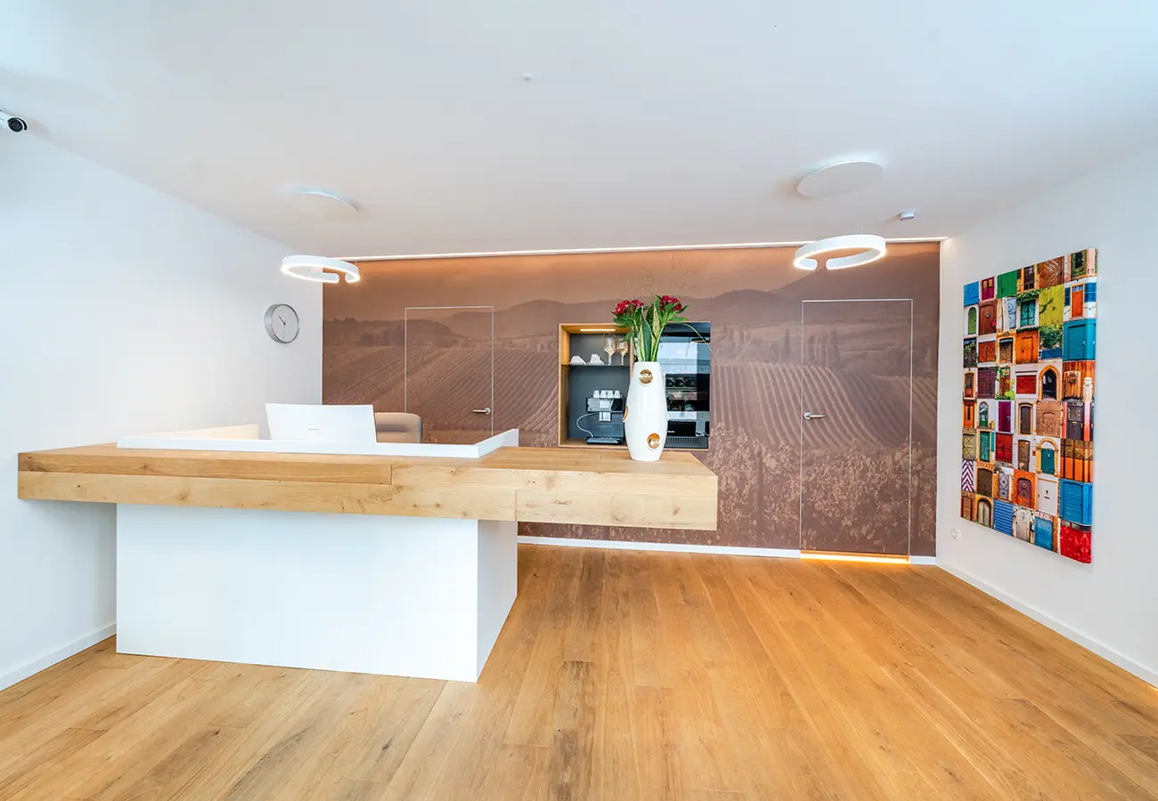 Empfangstheke mit Eichenauflage vor der bedruckten Wand