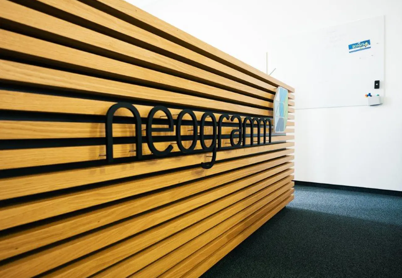Empfangswand aus Holzlamellen mit dem Schriftzug neogramm