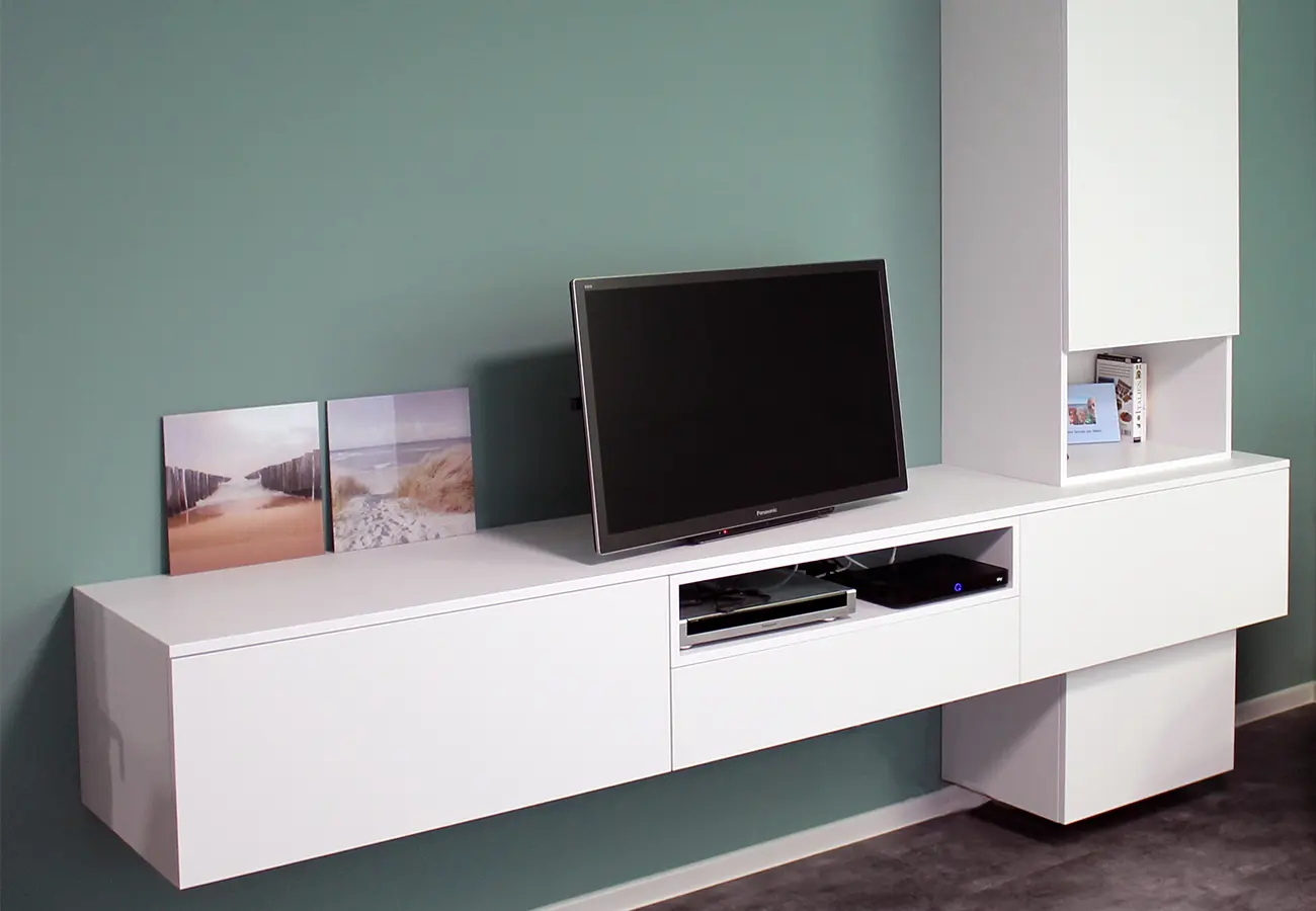 Wandhängendes Lowboard mit Fernseher vor grüner Wand