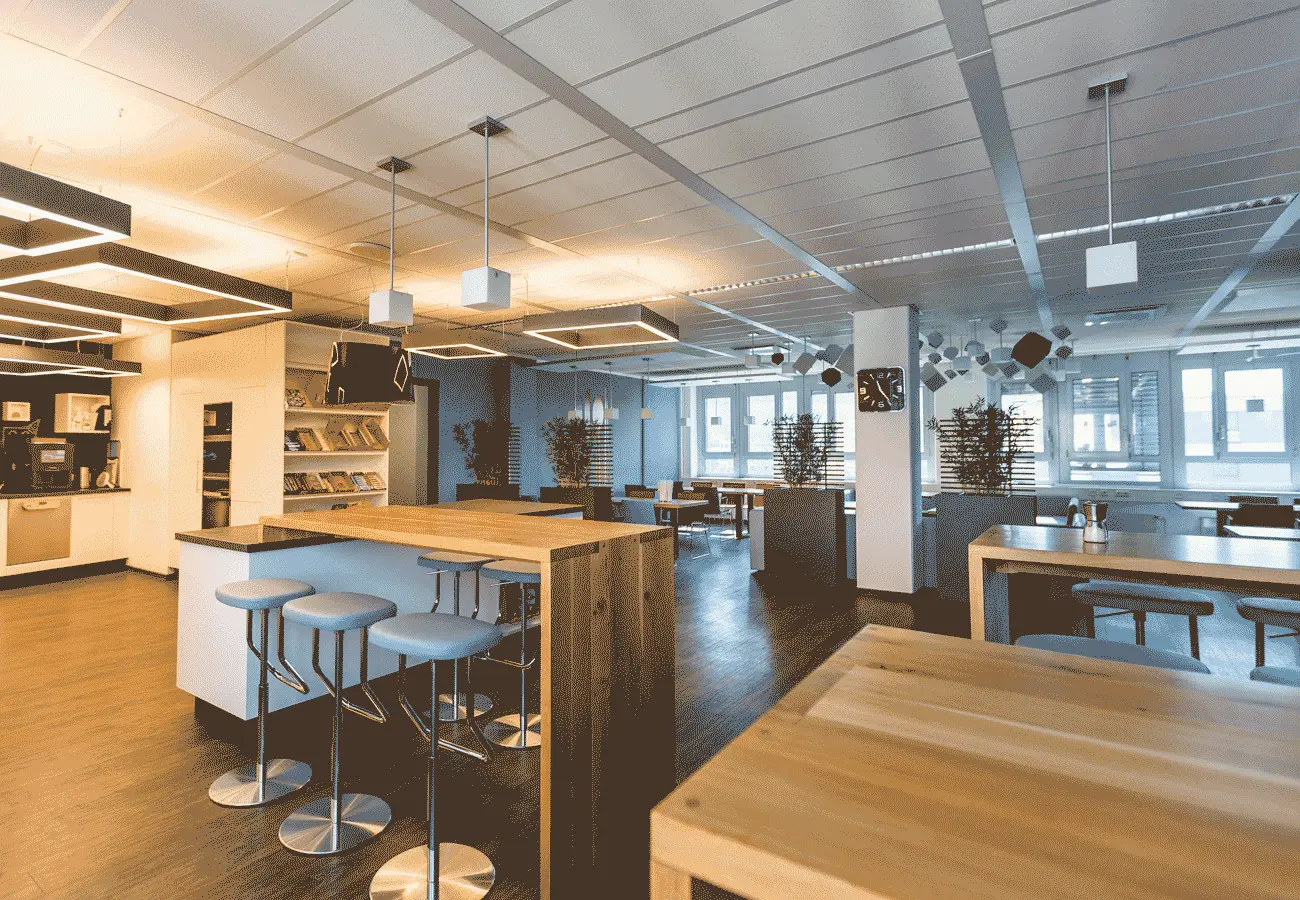 Betriebsrestaurant mit Theke, Stehtischen und Akustikelementen an der Decke